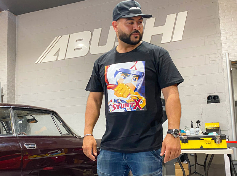Roscoe, owner of Abushi Automotive Group wears speed racer inspired Mach3 auto racing t-shirt by STUNTX.